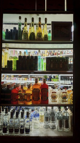 Bottles of various spirits on an illuminated shelf, Prague, Czech Republic