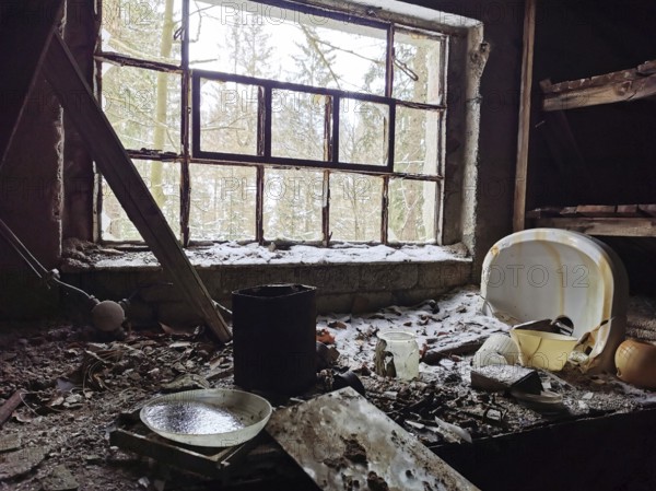 Abandoned building with snow-covered window and forest view