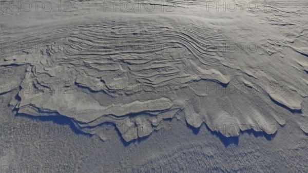 Close-up of wavy erosion patterns in sand