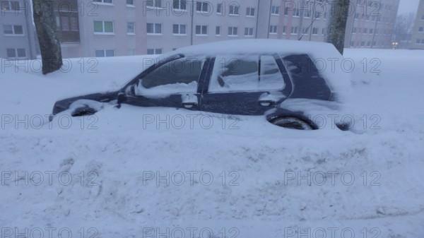 Snowy car parked in urban area after snowfall