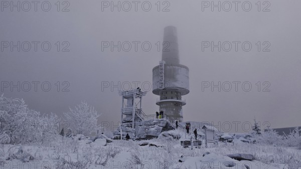 People in snowy surroundings with tower in fog as a central point, Backoefele on the Schneeberg, Fichtelgebirge, Bavaria