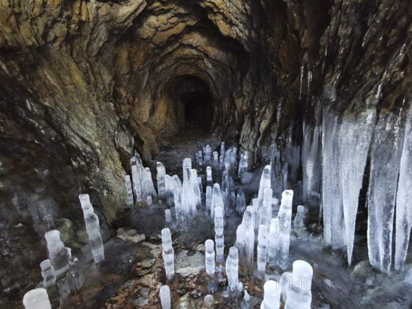 Ice cave with ice stalactites, icicles on rocky walls create a cold, mystical atmosphere, Franconian Forest nature park Park