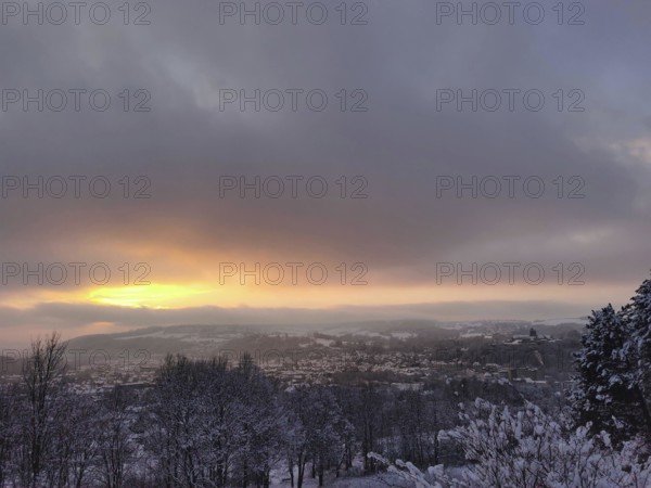 Snowy cityscape with golden sunset