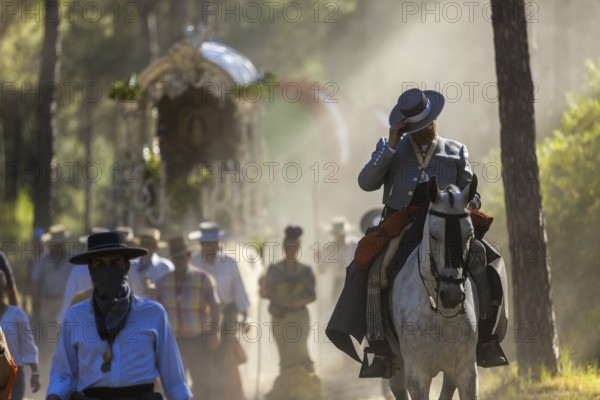 Donana National Park, Almonte, Huelva, Spain. Revellers in traditional equestrian clothes or Andalusian attire during the Romeria el Rocio on their way to the Town of El Rocio for the annual Feast dedicated to the Virgen del Rocio