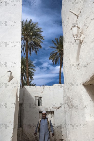 Ghadamis, Libya, North Africa. A bedouin walking through the whitewashed houses built traditionally with mud to keep cool in this last refuge before entering the unforgiving Sahara Desert