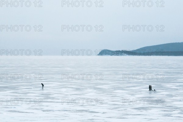 Lake Baikal, Siberia, Russia. People in the vast frozen lake in deep winter