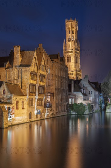 Bruges. Belgium. Flanders. Historic Houses and Town Hall tower in the old district overlooking a canal. UNESCO