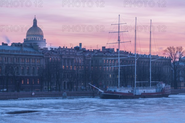 St Petersburg, Russia. St Isaac s Cathedral cupola seen from across the historic buildings on the Neva river with a ship stuck in the frozen river in Winter