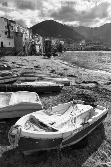 Traditional fishing boats on the shore, La Rocca mountain, monochrome, Tyrrhenian Sea, Cefalu, Cefalù, Sicily, Italy