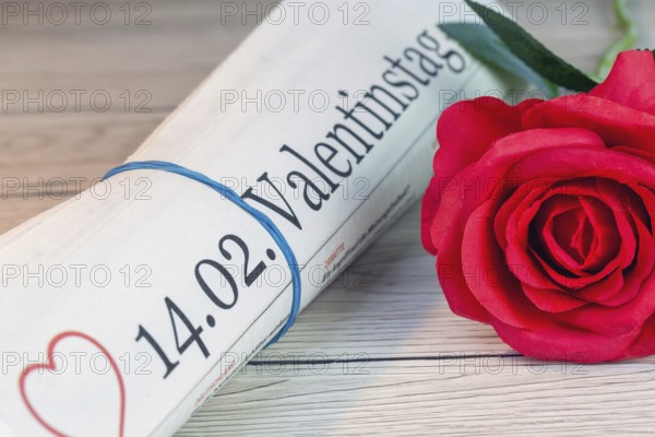 Symbolic newspaper with the title 14.02. VALENTINE'S DAY next to a red rose