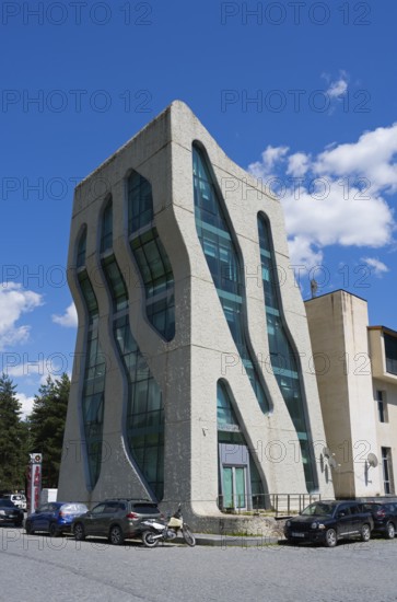 Modern, futuristic building with wavy glass facades and cars in front of it, police station designed by Jürgen Mayer, Mestia, Mingrelia and Upper Svaneti, Svaneti, High Caucasus, Georgia