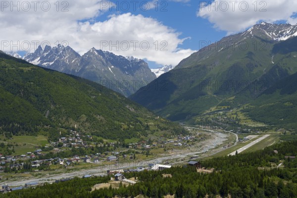 A view of a valley with a river surrounded by mountains and a village in the foreground, right airport, Mestia, Mingrelia and Upper Svaneti, Svaneti, High Caucasus, Georgia