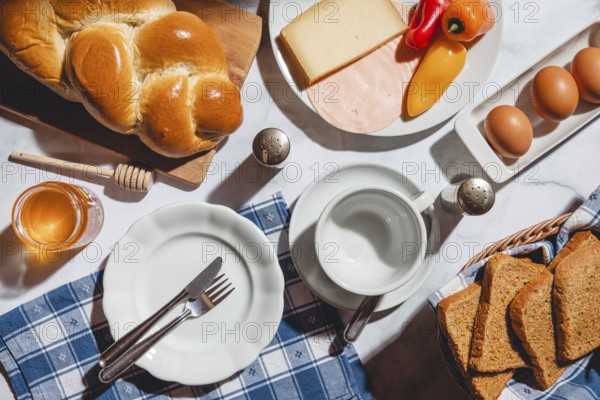 Breakfast with toast, stollen, honey, cheese, ham, peppers and eggs on a table