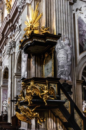 Richly decorated pulpit with intricate golden carvings, angel on the pulpit has symbolic meaning and serves as an announcing figure, by Antoni Frackiewicz, St. Anna Church in Baroque style, 1381, Krakow, Poland