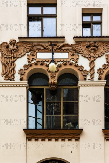 Czyncielow Art Nouveau house façade with intricate terracotta reliefs depicting snakes and an Aesculapian rod, Krakow, Poland