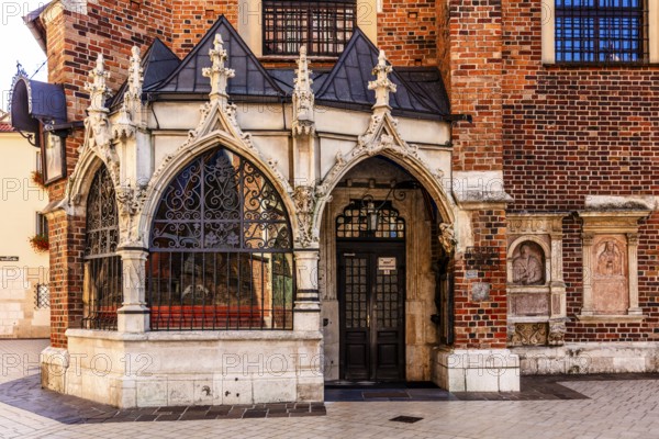 Entrance to St. Barbara Church, porch showing ornate Gothic stone carvings and wrought iron bars, Krakow, Poland