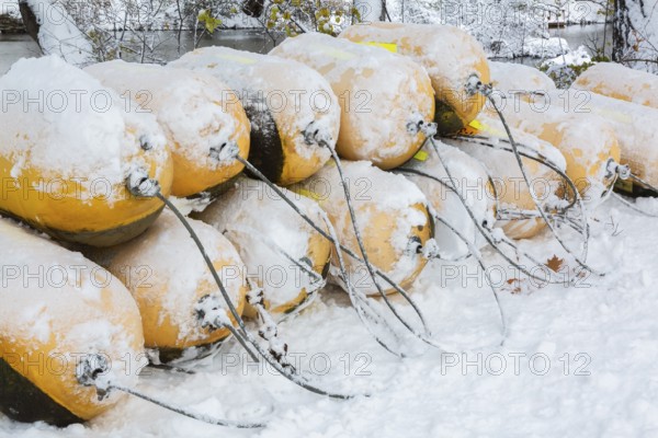 Close-up of stacked yellow cautionary river navigation buoys in storage and covered with winter like snow in late autumn, Ile des Moulins, Old Terrebonne, Quebec, Canada