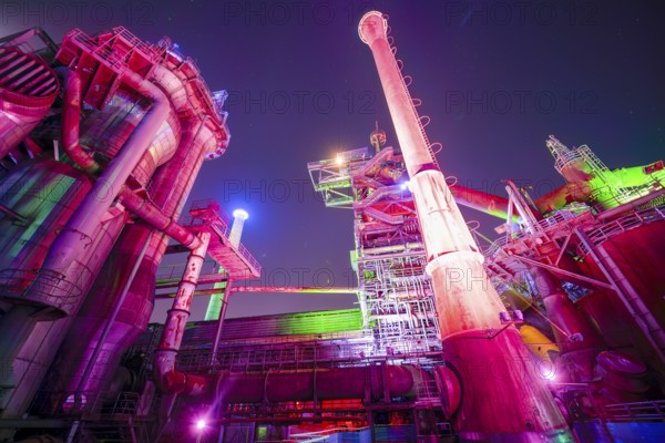 Colour-illuminated industrial ruins at night with pipes and futuristic character, Landschaftspark Duisburg Nord, Duisburg, North Rhine-Westphalia, Germany