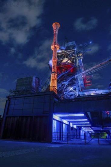 Futuristic industrial plant in glowing night light, Landschaftspark Duisburg Nord, Duisburg, North Rhine-Westphalia, Germany