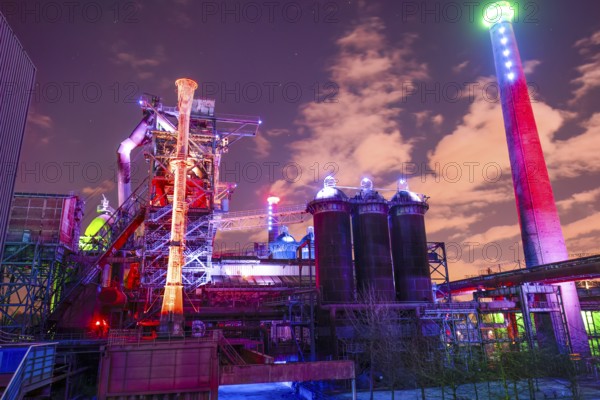 Colourful lighting on industrial buildings with visible chimney, Landschaftspark Duisburg Nord, Duisburg, North Rhine-Westphalia, Germany