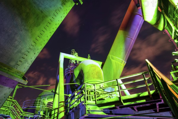 Detailed view of a metallic industrial plant illuminated with green and purple lights, Landschaftspark Duisburg Nord, Duisburg, North Rhine-Westphalia, Germany