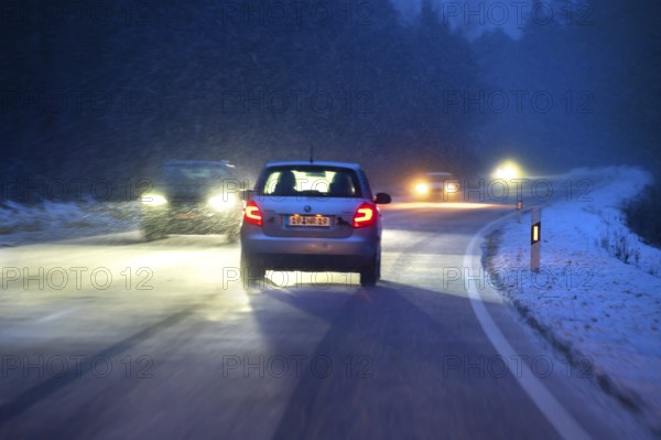 Cars during night snow flurries on B2, Heroldsberg, Middle Franconia, Bavaria, Germany