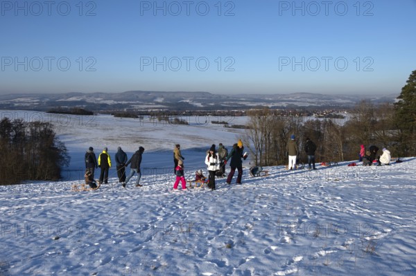 Tobogganing fun on a snow hill, Tauchersreuth, Middle Franconia, Bavaria, Germany