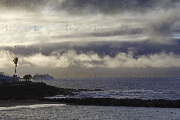Dramatic scenery with clouds over the sea and a distant ship, Playa Blanca Lanzarote