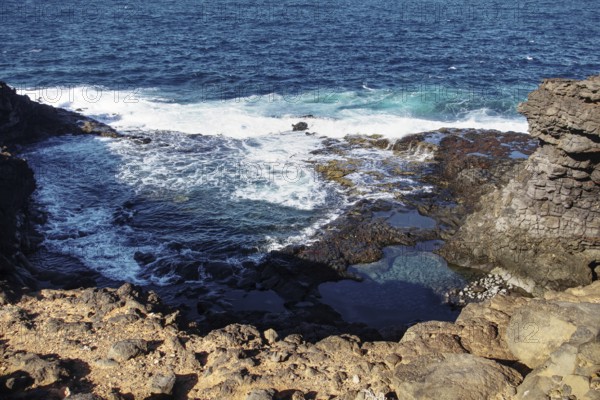 Coastal landscape with rocks in the foreground and riverbank surf in the background, Playa Blanca Lanzarote