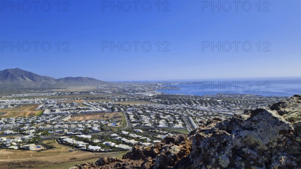 Panorama of the coastal town (Playa Blanca) with sea view and mountains under a clear sky, Playa Blanca Lanzarote