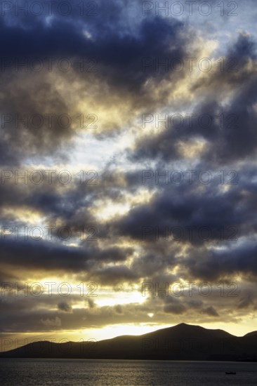 Dramatic sky during sunset, mountains in silhouette, light shows in the clouds, Puerto del Carmen Lanzarote