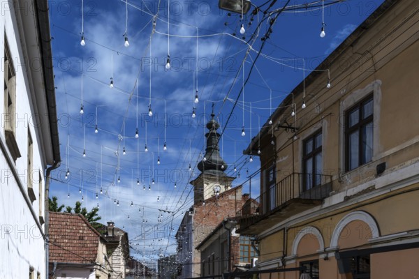 Light bulbs between houses for evening lighting, Cluj-Napoca, Transylvania, Romania