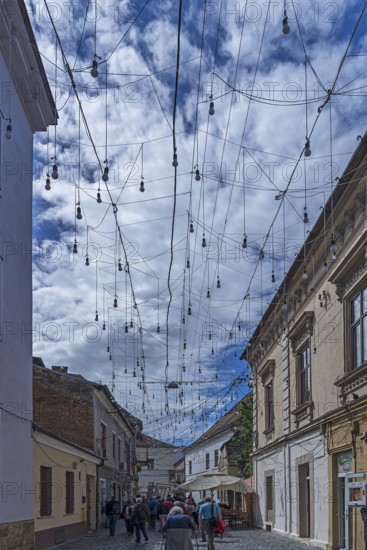 Light bulbs between houses for evening lighting, Cluj-Napoca, Transylvania, Romania