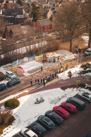 Aerial view of a street scene with people and cable drums in the snow, fiberglass groundbreaking, Freudenstadt, Germany