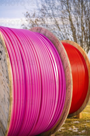 Large, coloured cable drums with pink and red cables outdoors, fibreglass groundbreaking, Freudenstadt, Germany