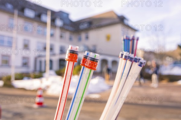 Colourful bundles of cables in front of a snow-covered building with people, fibreglass groundbreaking, Freudenstadt, Germany