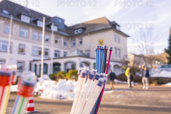 Colourful bundles of cables in front of a building, with snow-covered floor and people, fibreglass groundbreaking, Freudenstadt, Germany
