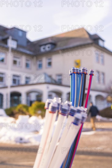 Colourful bundles of cables in front of a building and snow-covered ground, fibreglass groundbreaking, Freudenstadt, Germany