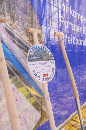 Spade in front of a poster referring to network expansion and construction, fiber optic groundbreaking, Freudenstadt, Germany