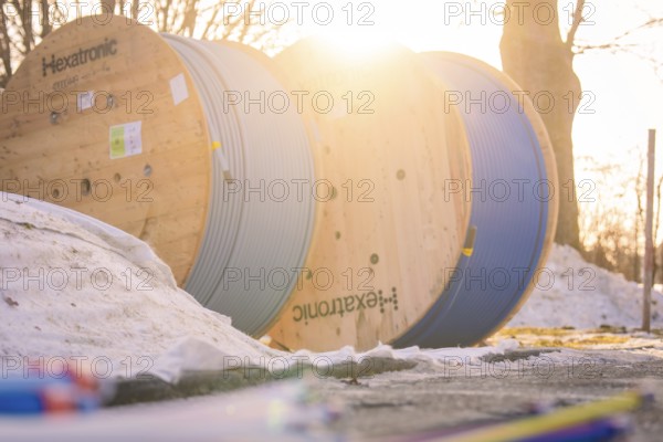 Cable drums in the snow, steeped in warm morning light, create a wintry atmosphere, fibreglass groundbreaking, Freudenstadt, Germany