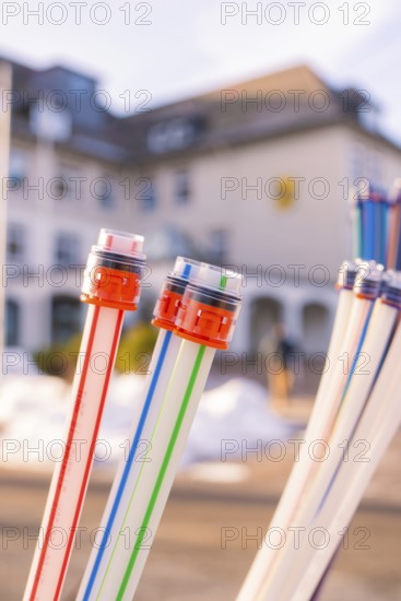 Colourful cables with coloured connectors in front of a blurred building, fibre-optic groundbreaking, Freudenstadt, Germany