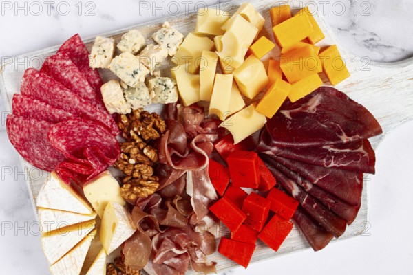 Assortment of cheese meat cuts, on a plate, top view, no people