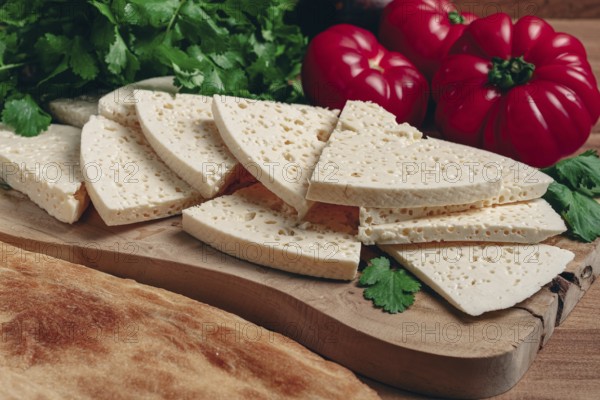 Georgian sliced cheese, on a wooden chopping board, with tomatoes with herbs and lavash, rustic style, Georgian cuisine, no people