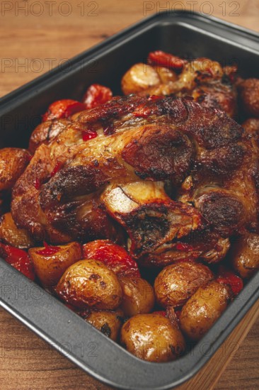 Pork knuckle, baked with vegetables, new potatoes, on a baking sheet, homemade, no people