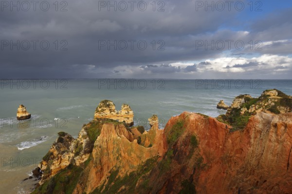 Rocky coast with storm cloud, Praia do Camilo, Lagos, Algarve, Portugal