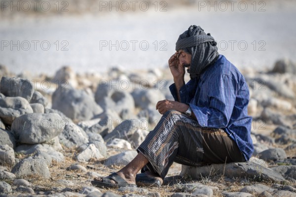 Nomad sitting on the ground thinking, Oman