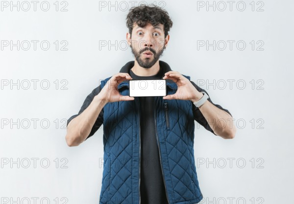 A surprised bearded man showing phone screen isolated. Shocked bearded guy showing promotion on screen phone