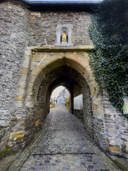 Historic medieval castle gate Matthiastor massive gate building made of quarry stone masonry from the 14th century, access to castle complex with castle bering from medieval Höhenburg Reifferscheid Castle historical landmark from the Middle Ages Excursion destination in Eifel, Reifferscheid, Hellenthal, Euskirchen district, North Rhine-Westphalia, Germany