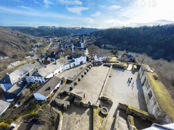 View from preserved castle tower to castle ruins Burghof restored preserved foundations remains of buildings bailey of medieval hill castle Reifferscheid tourist destination in Eifel, center left preserved old buildings of still inhabited historic Burgbering Reifferscheid, Hellenthal, Euskirchen district, North Rhine-Westphalia, Germany