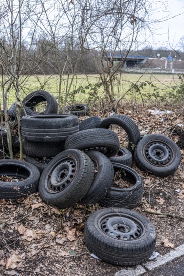 Illegally disposed of car tires and other trash, on a side street in Duisburg-Kaiserberg, North Rhine-Westphalia, Germany
